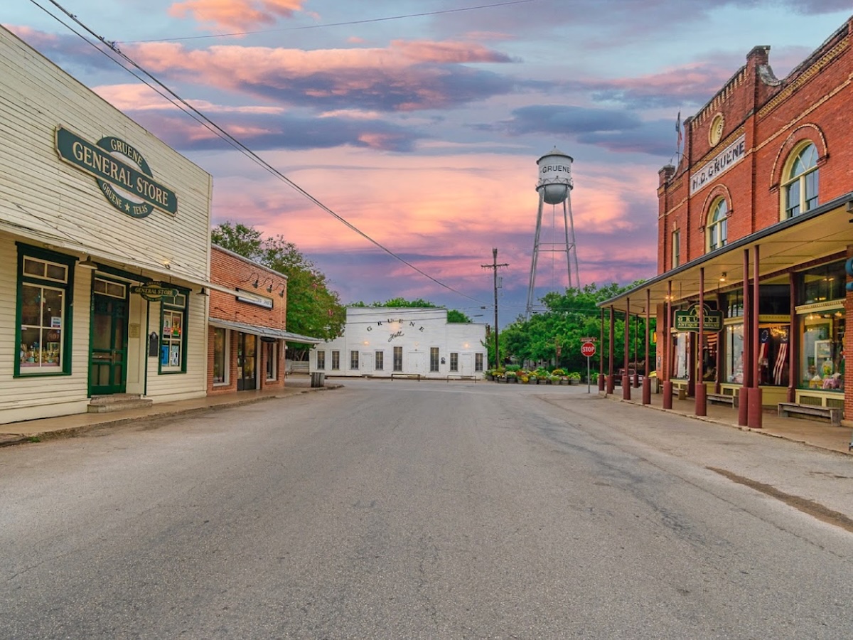 Termite Control Service in Gruene, Texas Historic downtown street with old buildings and a water tower at sunset