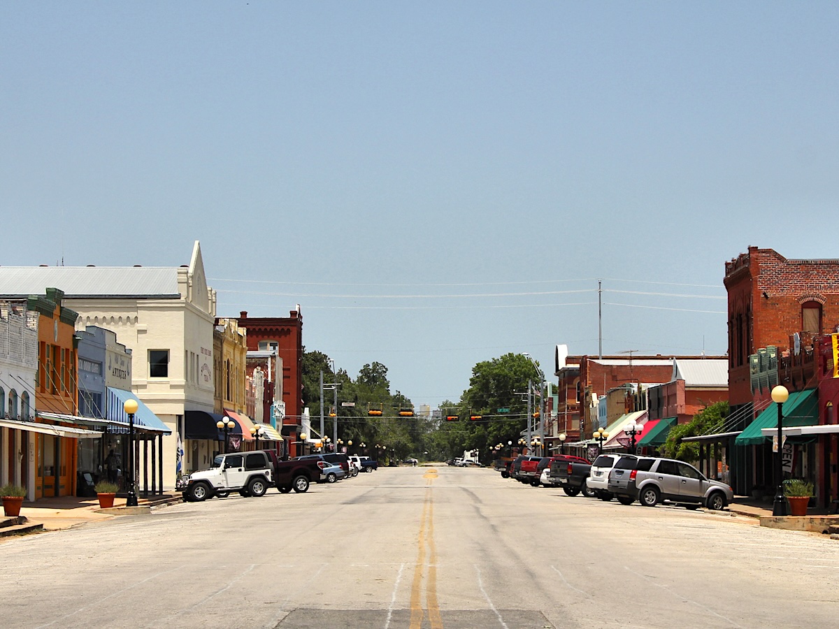 Termite Control Service in Smithville, Texas Empty street lined with historic storefronts and parked cars in a small town
