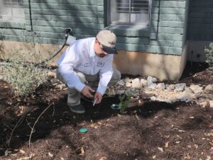 The Bug Master technician installs a termite bait station near a home.