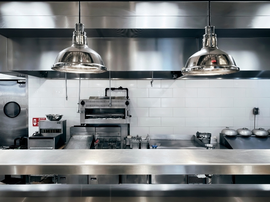A spotless commercial kitchen setup shows how proper cleanliness and organization can prevent pest problems. Keeping food prep areas clean, storing ingredients off the floor, and maintaining a routine cleaning schedule are essential steps to deter rodents and roaches.